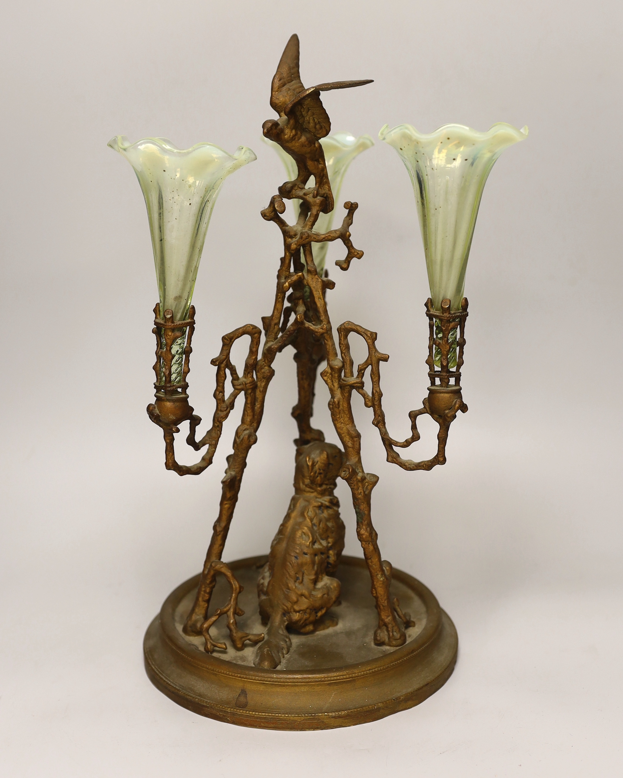 A gilt-metal three-branch epergne with seated dog and three opalescent green glass flutes, 41cm high